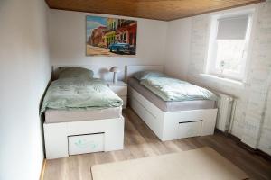two twin beds in a room with two windows at Ferienhaus Lotte in Vöhl