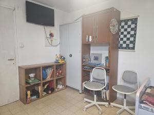 une chambre avec deux chaises et une étagère. dans l'établissement בית קרקע לנופש עם חצר גדולה במרכז קרית שמונה, à Qiryat Shemona 6 autres photos