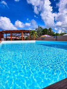 una gran piscina con un cielo azul en el fondo en Evasion en plein cœur de la ville T2 Jacuzzis Sauna et piscine au centre de Port-Louis, en Port-Louis
