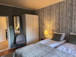 a bedroom with two beds and a dresser and a mirror at Cozy and spacious country house in Kakskerta in Turku