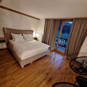 a bedroom with a bed and a large window at Apartman 452 sa pogledom na stazu Hotel Vučko private host in Jahorina +17 photos