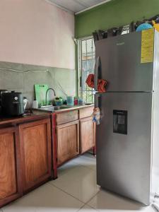 a kitchen with a stainless steel refrigerator and wooden cabinets at Black Widow in Horquetas