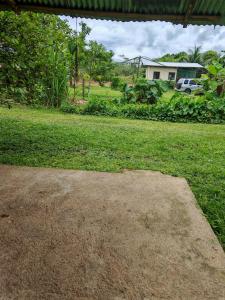 a yard with a field of grass and a house at Black Widow in Horquetas