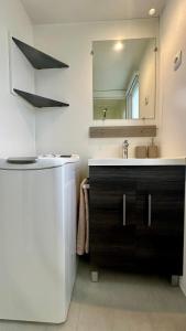 a bathroom with a sink and a mirror at Mobil-home camping 4 étoiles à Valras-Plage Clim Piscine Proche Mer 6 à 8 pers in Valras-Plage