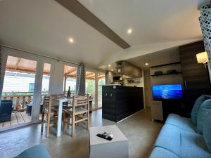 a living room with a blue couch and a table at Mobil-home camping 4 étoiles à Valras-Plage Clim Piscine Proche Mer 6 à 8 pers in Valras-Plage