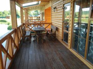 a wooden porch with a table and chairs on it at Zarichna in Drogobych
