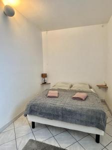 a bedroom with a bed with two towels on it at Le Nid du Port in Étaples