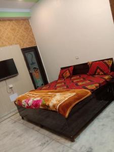 a bedroom with a large bed with a comforter at Guru Kripa Dham in Vrindāvan