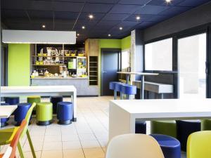 a restaurant with blue and green chairs and tables at Ibis Budget Orly Chevilly Tram 7 in Chevilly-Larue