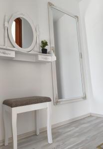 a white dressing table with a stool and a mirror at Apartma Ariana in Loče pri Poljčanah