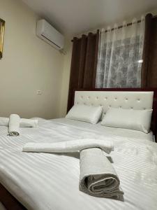 a bedroom with a bed with towels on it at Gledys House in Krujë