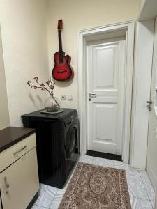 a room with a washing machine and a guitar on the wall at Gledys House in Krujë