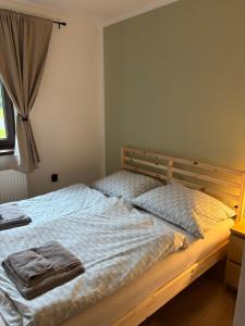 a bedroom with a bed with two towels on it at Apartmány Borovice in Josefŭv Dŭl