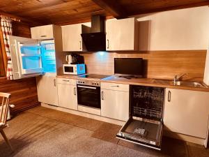 a kitchen with white cabinets and a sink and a microwave at Ferienhaus Unterkircher-Wallner in Heiligenblut
