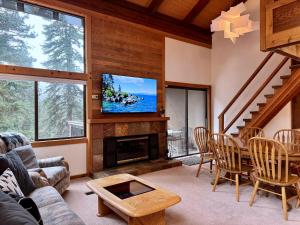 Una sala de estar con chimenea y televisión. en Lofty Retreat, Condo in Northstar, en Truckee