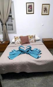 a bed with two blue gloves on top of it at Studio Villa Emeli, close to beaches and downtown in Porto Heli +33 photos