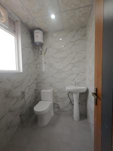 ein Badezimmer mit weißer Toilette und Waschbecken in der Unterkunft Hostro Stays in Jaipur