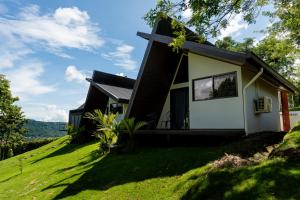 a house with a cross on the side of it at Villa Bosque CR in Turrialba