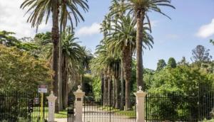 a wrought iron fence with palm trees in the background at Fulton Flow Resort Apartment in Melbourne