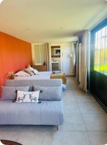 a living room with two beds and a couch at Villa du lac in Arsac