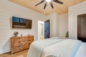 une chambre avec un lit et un ventilateur de plafond dans l'établissement Crimson Creek Cabin - Hot Tub, Playset, Family-Friendly, à Broken Bow