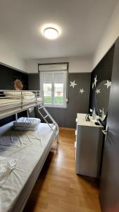 a bedroom with a bed and a desk with stars on the wall at Duplex les pieds dans l'eau in Grandcamp-Maisy