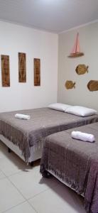 two beds sitting next to each other in a room at Pousada Porto Tutóia in Tutóia