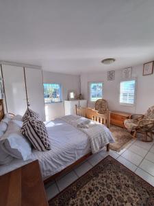 a bedroom with a bed and a desk and chairs at See-Rus Self Catering Seaside Accommodation in Jacobs Bay