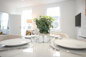 a table with white plates and a potted plant on it at 1B Lime Street in Bedford