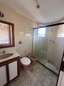 een badkamer met douche, toilet en wastafel bij Apartamento 3 suítes perto da Praia do forte e Passagem in Cabo Frio