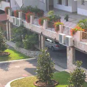 an apartment building with a car parked under a bridge at Residence Miralago Rooms & Apartments in Manerba del Garda