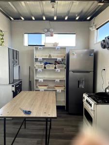 a kitchen with a table and a refrigerator at Hab baño compartido, 10 cdas Plaza de Armas, con terraza y vista a los volcanes in Arequipa