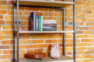 une étagère avec des livres à côté d'un mur de briques dans l'établissement Prime Location Top Rated Clean Parking Free!, à Columbus