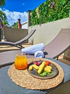a plate of food and a drink on a table at Evasion en plein cœur de la ville Studio Jacuzzis Sauna et piscine au centre de Port-Louis in Port-Louis