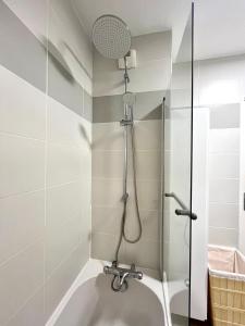 a bathroom with a shower with a sink at T2 cosy avec parking - Goupama Stadium LDLC Arena in Décines-Charpieu +29 photos