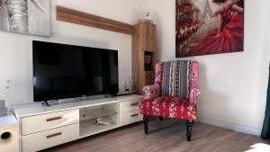 een woonkamer met een tv en een stoel bij Villa Wewelsburg in Büren