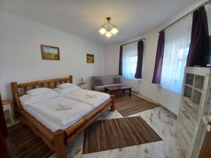 a bedroom with a bed and a couch at Piramis Pihenőpark in Demjén