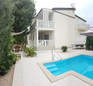 a villa with a swimming pool in front of a house at Villa Ana Sevid in Sevid