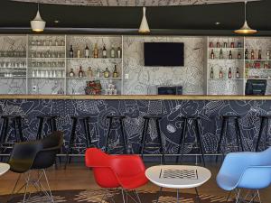 a bar with colorful chairs and a tv at Ibis Culiacan in Culiacán