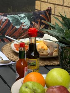 a table with apples oranges and bottles of sauce at The Hide Nongoma in Nongoma