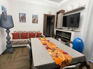 Una sala de estar con una mesa y un televisor. en Belvedere Dei Trabocchi, en Ortona