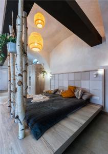 a bedroom with a large bed with fake trees on it at Moderní a útulné studio na statku z roku 1880 in Prague