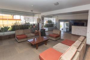 a man sitting on a couch in a living room at Casa Andina Standard Arequipa in Arequipa
