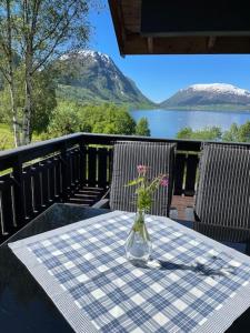谢伊Kjøsnes Feriehytter的桌上放着一瓶鲜花，桌上铺着桌布