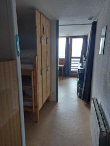 Zimmer mit einem Schlafzimmer mit einem Etagenbett und einem Schreibtisch in der Unterkunft Appt 4 prs Tour de La Biche depart skis aux pieds in Besse-et-Saint-Anastaise