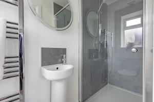 Un baño blanco con lavabo y ducha en North Hill House, en Great Malvern