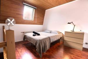 Schlafzimmer mit einem Bett, einem Schreibtisch und einem Ventilator in der Unterkunft Maison 2 ch, 3 lits, près de Lille & transports in Lezennes