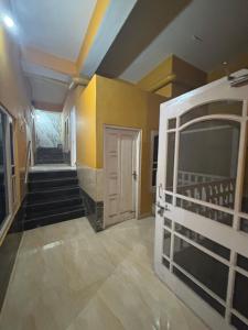 einen Flur mit einer weißen Tür und ein Zimmer mit einer Treppe in der Unterkunft bhagwati homestay in Chamba