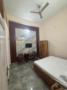a bedroom with a bed and a table and a television at bhagwati homestay in Chamba
