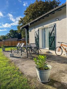 eine Gruppe von Stühlen und ein Fahrrad, die neben einem Haus geparkt sind in der Unterkunft Maison chaleureuse in Mézos